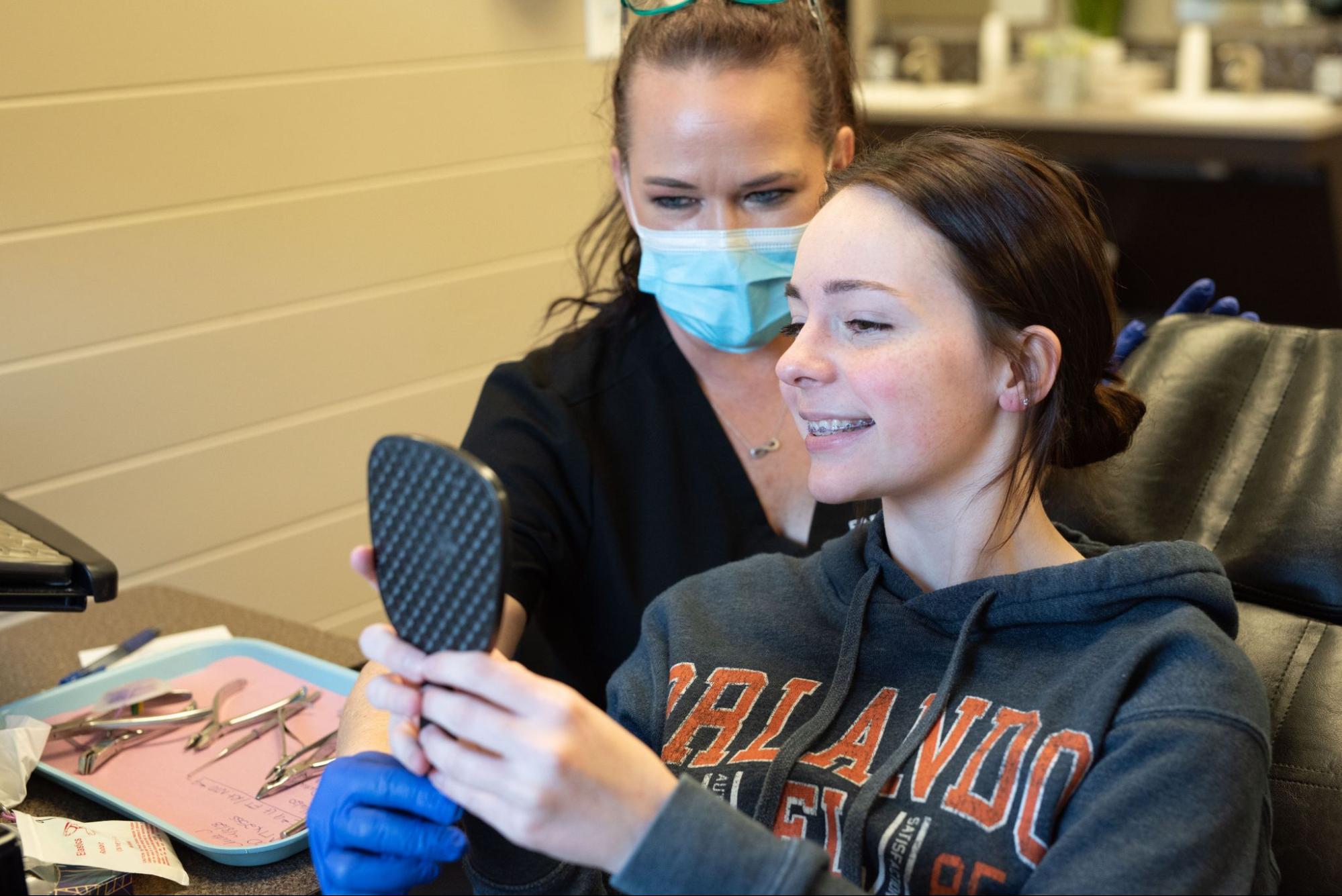Teen girl looking at her new braces in Lubbock